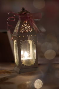 Close-up of illuminated light bulb hanging at night