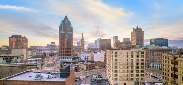 Buildings in city against cloudy sky