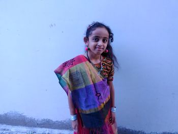 Portrait of girl standing by wall