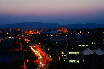 Light trails in city against sky at night