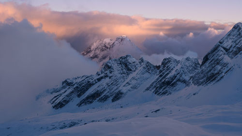 Scenic view of snowcapped mountains against sky during sunset