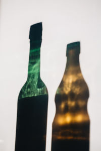 Silhouette of glass bottles against white background