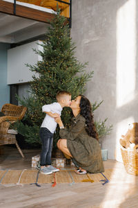 Mom and son kiss each other in anticipation of the christmas and new year holiday