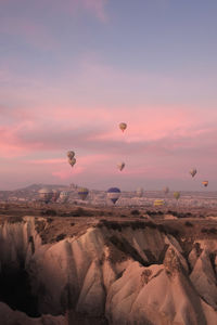 Hot air balloons flying against sky during sunset