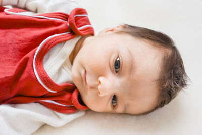 Close-up portrait of cute baby lying on bed