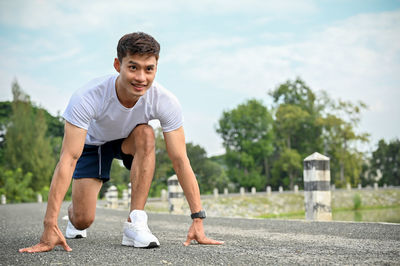 Portrait of young man exercising on road