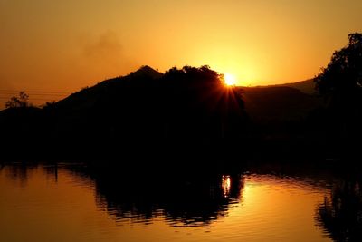 Scenic view of lake against orange sky