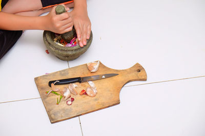 Cropped hand of woman preparing food in mortar and pestle
