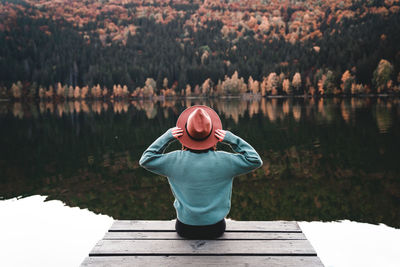 Rear view of woman standing by lake