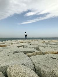 Man standing on beach against sky
