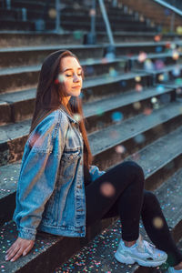 Side view of woman sitting on staircase