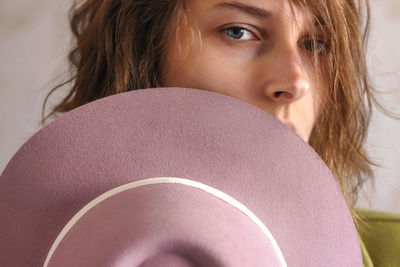 Portrait of young woman against wall at home