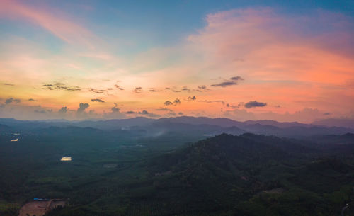 Scenic view of mountains against dramatic sky during sunset