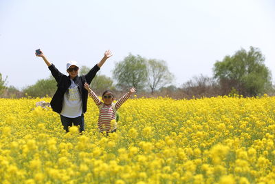 Full length of mother and daughter standing on field