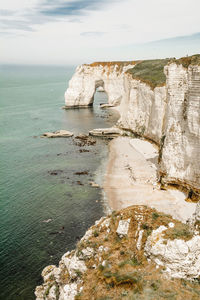 Rock formations by sea against sky