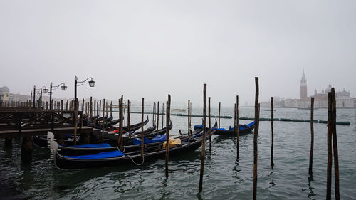 Boats moored in sea against clear sky