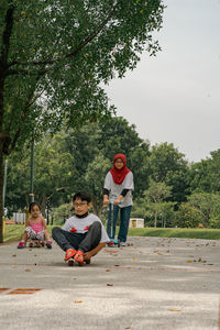 Side view of woman sitting on swing at park