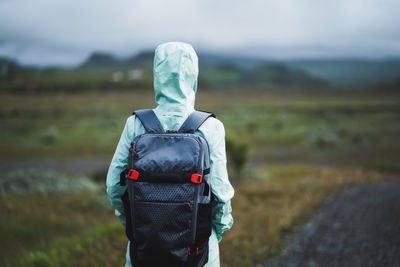 Woman with backpack and green jacket on travel in iceland