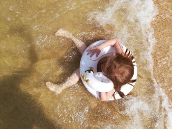 High angle view of girl with inflatable ring at beach