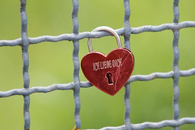 Close-up of heart-shaped lock on fence