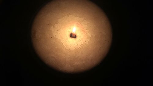 Close-up of illuminated candle in darkroom