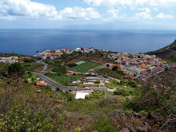 High angle view of townscape by sea against sky