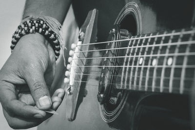 Midsection of man playing guitar