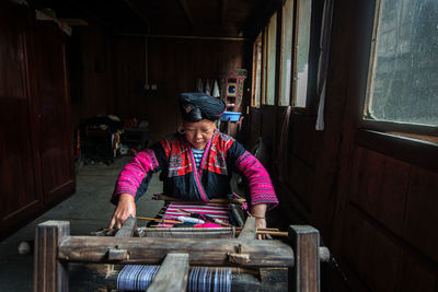 Mature woman weaving at workshop