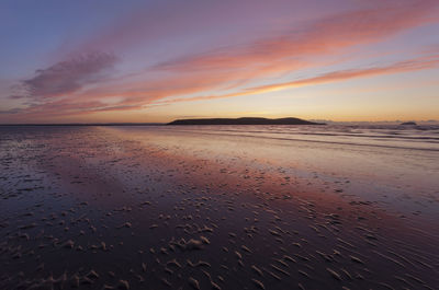 Scenic view of beach against sky during sunset