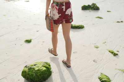 Low section of woman walking at beach