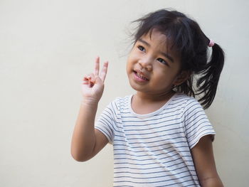 Close-up of cute girl standing against wall