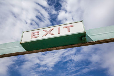Low angle view of information sign against sky