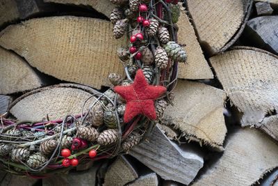 Detail from a advent wreath in front of an stack of wood 