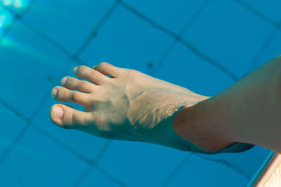 Cropped image of human leg in swimming pool