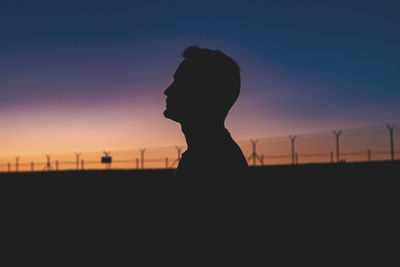 Silhouette men standing against clear sky during sunset