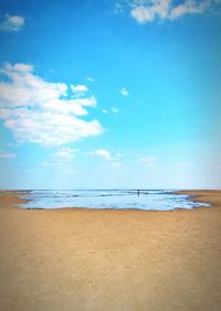 Scenic view of beach against blue sky