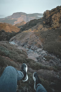 Low section of man standing on mountain