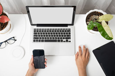 Cropped hands using laptop on table