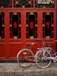 Bicycle's parked in front of red doors in pingyao