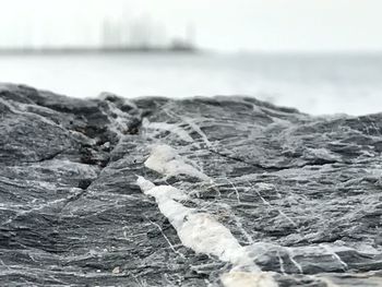 Close-up of rocks in sea against sky