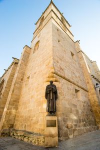 Low angle view of cross on building against sky