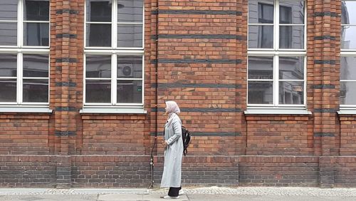 Full length of woman standing against building