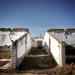 Abandoned building against clear blue sky