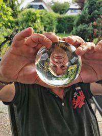 Upside down image of man reflecting in crystal ball