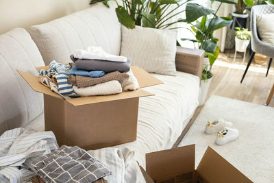 Low section of woman sitting on sofa at home