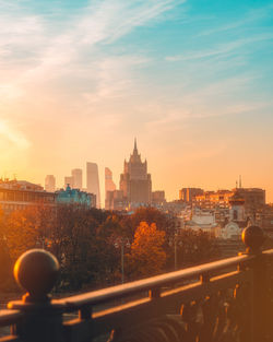 Buildings against cloudy sky during sunset in city