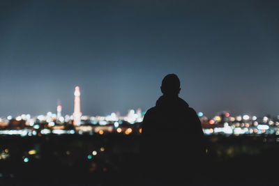 Rear view of city lit up at night