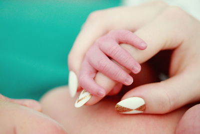 Woman holding hands with baby