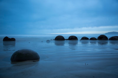 Rocks in sea against sky