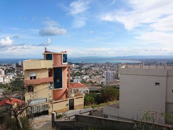 High angle view of townscape by sea against sky